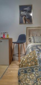 a bedroom with a blue chair next to a bed at Skyline by Nights & Smiles in Tuzla