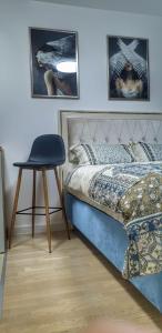 ein Schlafzimmer mit einem Bett und einem Stuhl darin in der Unterkunft Skyline by Nights & Smiles in Tuzla