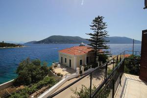 a house on the shore of a body of water at Sonia's Apartment in Fiscardo Waterfront in Fiskardo