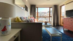 a living room with a table and a large window at APARTELLO Modern Apartment - Balkan Breeze 7 in Sunny Beach