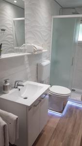 a white bathroom with a sink and a toilet at Casa Tomadero in Bol