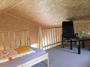 HoltseeにあるEiderhufeのベッド1台、椅子、テーブルが備わる客室です。