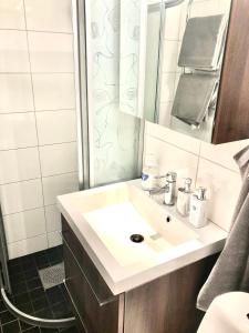 a bathroom with a white sink and a mirror at Lovely studio in the citycenter of Sigtuna in Sigtuna
