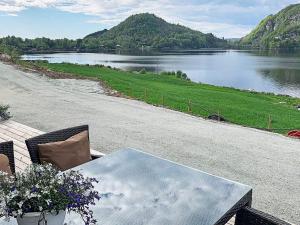 a table and chairs with a view of a lake at 6 person holiday home in Tau in Tau