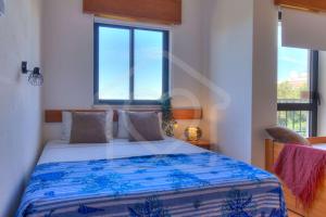 a bedroom with a large bed with blue and white sheets at Villas2go2 Studio Alvor in Alvor