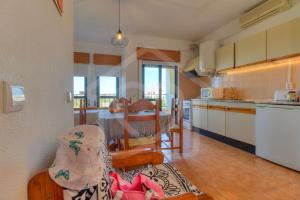 eine Küche und ein Wohnzimmer mit einem Tisch und einer Küche in der Unterkunft Villas2go2 Studio Alvor in Alvor