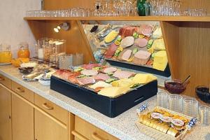 a buffet with many different types of food on a counter at Hotel-Pension Altes Siel in Bensersiel