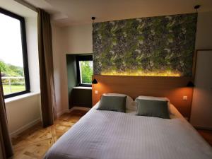 a bedroom with a large white bed with two pillows at Domaine de Stang Bihan in Concarneau