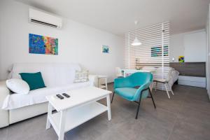 een woonkamer met een witte bank en een tafel bij Studio 87 in Dubrovnik