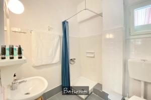 a white bathroom with a sink and a shower at Afitos Beach Apartments in Afitos +31 photos