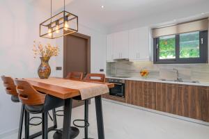 a kitchen with a wooden table and chairs and a vase at Allegra Villa in Kipseli