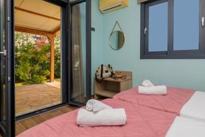 twee bedden met handdoeken in een kamer bij Allegra Villa in Kypseli