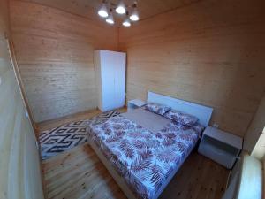 una habitación de madera con vistas panorámicas a una cama en ZHANUYA HOUSE, en Burabay