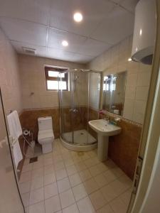 a bathroom with a shower and a toilet and a sink at سارا للشقق الفندقية Sara Furnished Apartments in Al Khobar