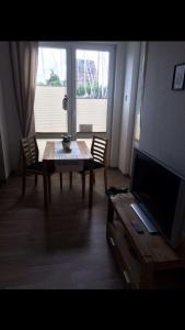 sala de estar con mesa y TV en Ferienwohnung-Bieberblick, en Greifswald