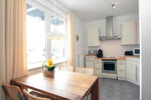a kitchen with a wooden table and a large window at Ferienwohnung-Bieberblick in Greifswald