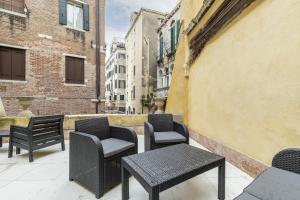 a group of chairs and tables on a balcony at Gondola Luxury - Campo Santi Filippo e Giacomo in Venice