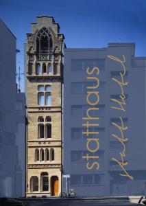 ein hohes Gebäude mit einem Schild an der Seite in der Unterkunft statthaus - statt hotel in Köln