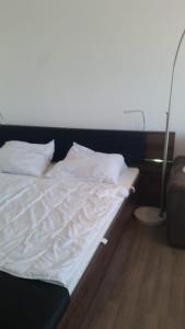 a bed with white sheets and pillows in a room at Ferienwohnung-Suedstrandflair in Burgtiefe auf Fehmarn  +1 photo