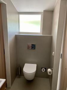 een kleine badkamer met een toilet en een raam bij Overnachting Vanjewelste in Enschede