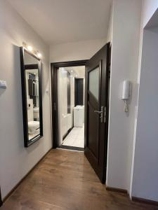 un corridoio di un bagno con porta e specchio di 02 Gdynia Centrum - Apartament Mieszkanie dla 2 os a Gdynia
