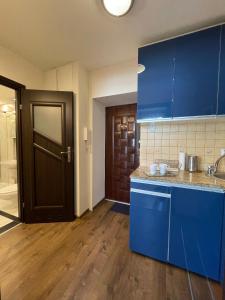 una cocina con armarios azules y una puerta azul en 02 Gdynia Centrum - Apartament Mieszkanie dla 2 os en Gdynia