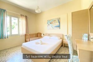 a bedroom with a bed with a table and a desk at Afitos Beach Apartments in Afitos