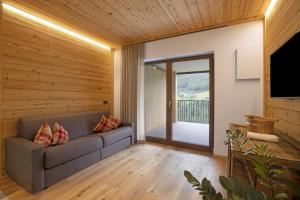 a living room with a couch and a television at Archehof Hochzirm Lodge Johanna in Campo Tures