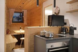 a kitchen with a counter with pots and pans at Archehof Hochzirm Lodge Greti in Campo Tures