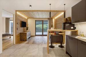 a kitchen and living room with wooden walls at Archehof Hochzirm Lodge Anna in Campo Tures