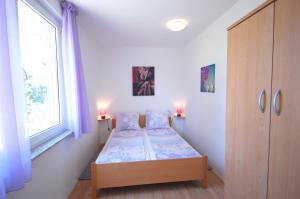 a small bedroom with two beds and a window at Apartment Blanka in Njivice