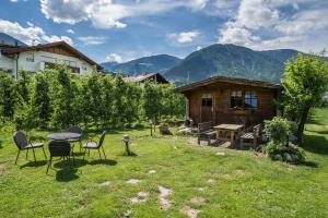 a backyard with a table and chairs and a cabin at Apartment Gantkofel Leilichhof in Lana