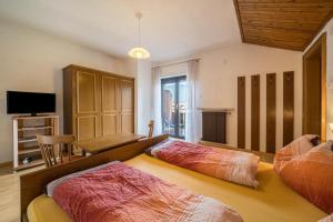 a bedroom with two beds and a television in it at Apartment Gantkofel Leilichhof in Lana
