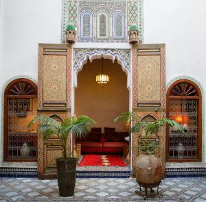 a living room with a red couch in a building at Riad Idrissy in Fès