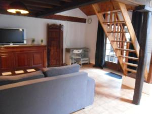 a living room with a couch and a staircase at la mini ferme de maëlou in Sermaises