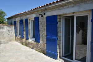 una fila de puertas azules en un edificio de piedra en Le Chai de Saint-Pierre en Saint-Pierre-dʼOléron
