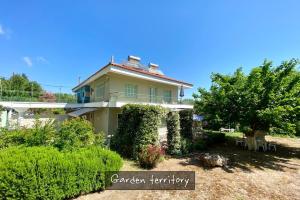 a house with a garden in front of it at Afitos Beach Apartments in Afitos