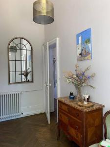 a living room with a dresser and a mirror at Aile Château La Chapelle du Bois des Faulx in La Chapelle-du-Bois-des-Faulx