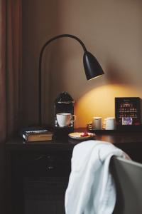 a desk with a lamp and coffee cups on it at Stord Hotel in Stord