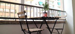 a chair and a table and a plant on a balcony at KAMCHŪ APARTMENTS: VIALE LIBIA in Rome