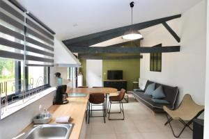 een keuken en een woonkamer met een tafel en een bank bij L'atelier et sa terrasse in Pontivy