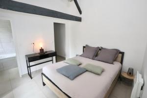 1 dormitorio con 1 cama con 3 almohadas en L'atelier et sa terrasse en Pontivy