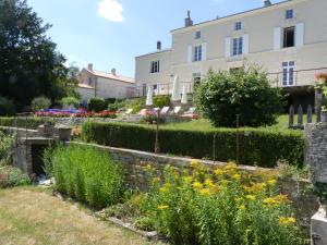 Xanton-Chassenon的住宿－Les Jardins de Xanton，一座花园,在一座建筑前种有鲜花