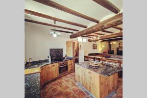 uma grande cozinha com armários de madeira e bancadas de granito em Casa: Mirador del Valle perdido. em Enciso