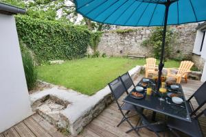 een tafel en stoelen met een parasol op een patio bij L'atelier et sa terrasse in Pontivy