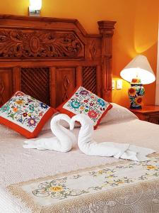 a bed with two towels in the shape of a heart at Hotel Rosalia in Valladolid