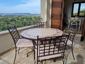un tavolo e sedie su un balcone con vista di Alghero - House with Panoramic View immersed in full nature ad Alghero