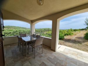 una sala da pranzo con tavolo e sedie sul balcone di Alghero - House with Panoramic View immersed in full nature ad Alghero