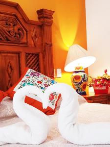 two swans made out of towels sitting on a bed at Hotel Rosalia in Valladolid