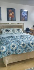 a bedroom with a bed with a blue and white blanket at Passion by Nights & Smiles in Tuzla